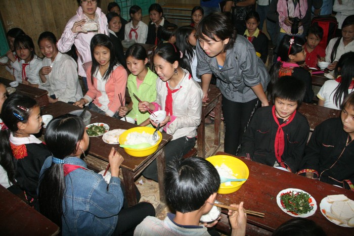 Bữa cơm đạm bạc chỉ có cơm và canh của học sinh Nậm Mười khiến ca sỹ Thái Thùy Linh phải nghẹn lòng. Đoàn công tác Báo Giáo dục VN đã chuẩn bị một sẵn một chút thức ăn mang lên góp vào bữa ăn của các em. Ảnh: Văn Trinh