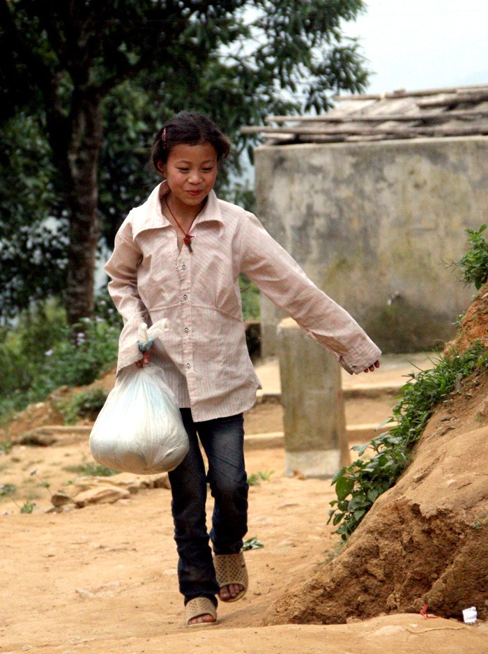 Một học sinh trường THCS Nậm Mười vui vẻ mang gạo tới trường.
