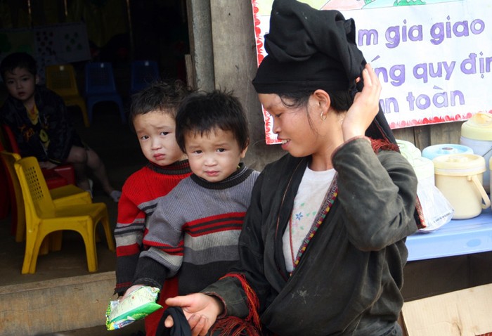 Hai anh em sinh đôi Bàn Ton Liều - Bàn Ton Khách được mẹ địu đến trường mầm non.