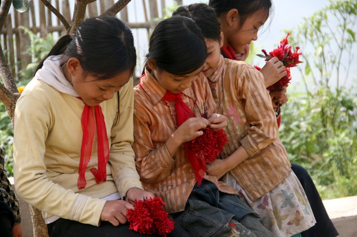 Giờ ra chơi của học sinh Tiểu học Nậm Mười. Các em gái đang ngồi tết những bông hoa rừng.