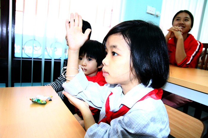 Một em nhỏ giơ tay trả lời khi Thái Thùy Linh đặt câu hỏi.