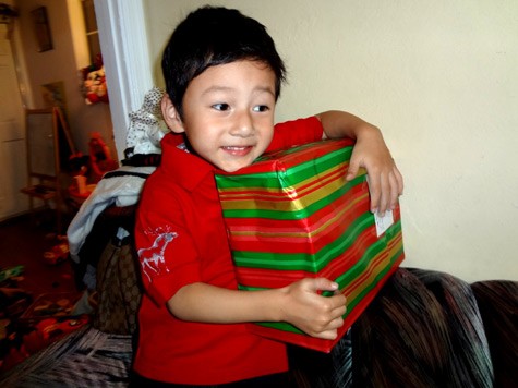 Khuôn mặt phấn khởi của cậu bé khi nhận được món quà từ ông già Noel.