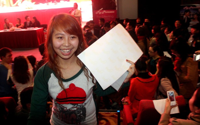 Một bạn gái cười tươi khi được Song Seung Hun ký tặng.