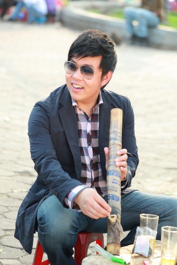 Quang Lê thể hiện phong cách dân dã: hút thuốc lào ở Hà Nội.