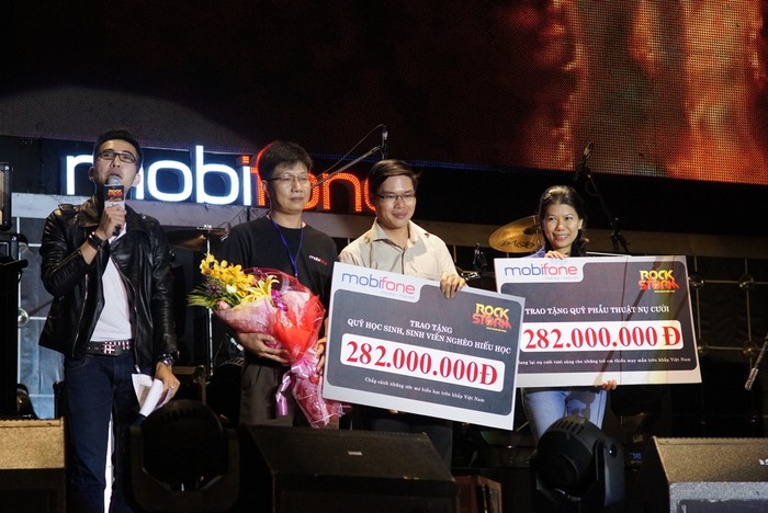 Đại diện MobiFone trao tặng số tiền từ thiện cho Quỹ Phẫu thuật nụ cười (ngoài cùng bên phải) và Quỹ Học sinh – sinh viên nghèo hiếu học của Trung ương Đoàn trên sân khấu RockStorm TP.Hồ Chí Minh