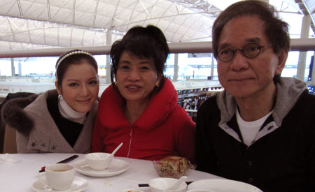 Lý Nhã Kỳ chụp ảnh kỷ niệm cùng bố mẹ nuôi tại sân bay Hongkong.