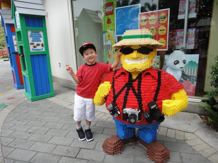 Cậu bé nhí nhảnh chụp ảnh bên những bức tượng hài hước tại Legoland.