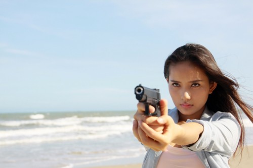 Người đẹp Phan Như Thảo với hình ảnh một chiến sĩ công an trong bộ phim "Ranh giới trắng đen" khi thực hiện cảnh quay ở biển vào tháng 4/2012. (Ảnh 24h)