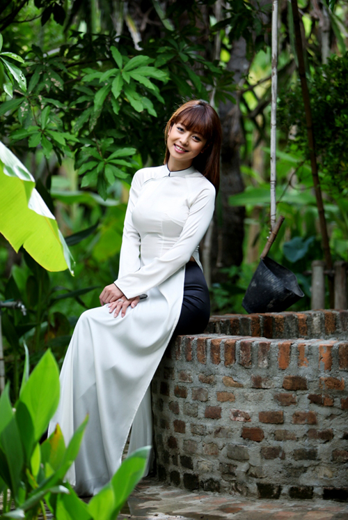Hoa hậu Jennifer Phạm diện áo dài trắng, hóa thân thành cô nữ sinh e ấp giữa cảnh vườn nhà yên bình, xanh mát.