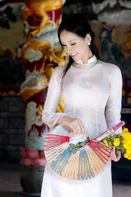 Hoa hậu Mai Phương Thúy chọn áo dài hoa, thiết kế cổ thấp tay lỡ để đi chợ Tết. Tà áo áo dài với gam màu nhẹ nhàng, kiểu dáng đơn giản giúp độc giả cảm nhận được nét văn hóa đặc trưng của Việt Nam.