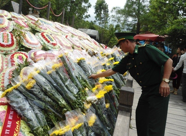 Các chiến sĩ bộ đội biên phòng xếp lại hoa nơi khu mộ