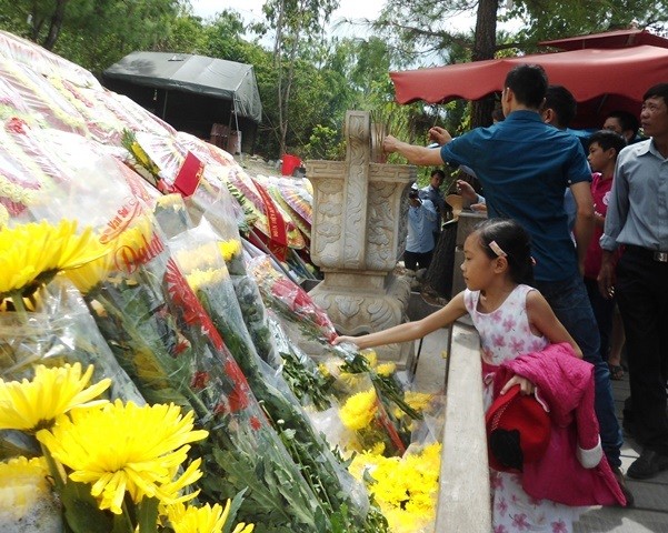 Một cô bé dâng hoa lên mộ Đại tướng