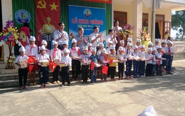 Lãnh đạo huyện Quảng Ninh và trường phổ thông dân tộc bán trú tiểu học Trường Xuân trao quà cho các em học sinh nghèo vượt khó