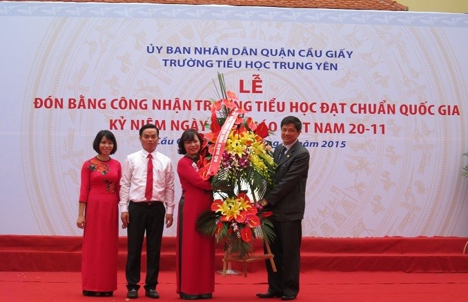 Ông Phạm Xuân Tiến – Phó giám đốc Sở GD&amp;ĐT Hà Nội trao bằng trường chuẩn quốc gia và tặng hoa cho Trường tiểu học Trung Yên (Ảnh: Thùy Linh)