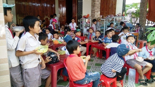 Tan học, hàng chục học sinh trường Tiểu học Quảng Thạch kéo nhau ra ăn cơm phía ngoài cổng trường (Ảnh: Thủy Phan)