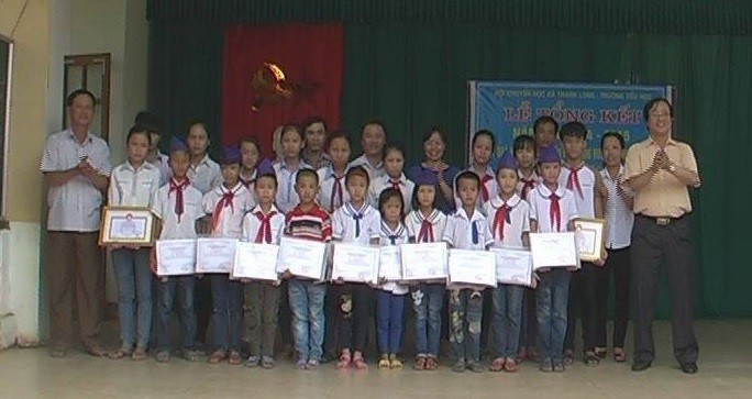 Thầy Phạm Đức Bảo (áo vàng) trao tặng 20 suất học bổng tới các em học sinh vào ngày 2/6/2015.