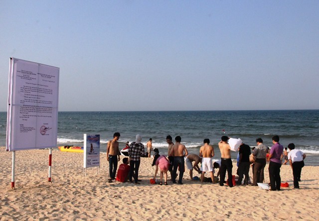 Lắp bảng thông báo kết luận nước biển an toàn ở bãi tắm Bảo Ninh (TP. Đồng Hới). (Ảnh: Minh Huyền)