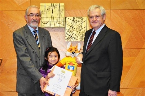 Thanh Mai, lúc 8 tuổi, nhận chứng chỉ vô địch vòng thi chung kết toán lớp 4 toàn tỉnh Unterfranken, Đức, năm 2011 (Ảnh nhân vật cung cấp)