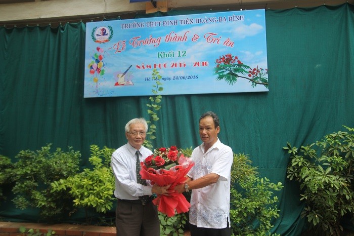 Đại diện phụ huynh học sinh tặng hoa cho lãnh đạo nhà trường.