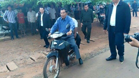 Thủ tướng Hun Sen đèo người xe ôm mà không mang mũ bảo hiểm - Ảnh: Khmer Times