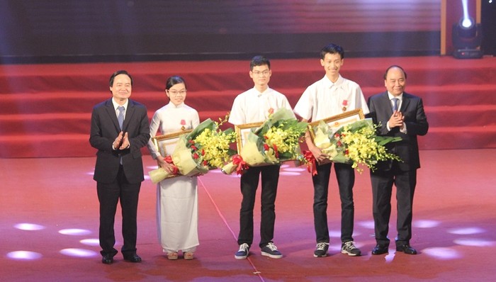 Thủ tướng Nguyễn Xuân Phúc và Bộ trưởng Bộ GD&amp;ĐT Phùng Xuân Nhạ trao tặng Huân chương Lao động hạng Ba cho học sinh đoạt giải Olympic quốc tế. (Ảnh: Thùy Linh)