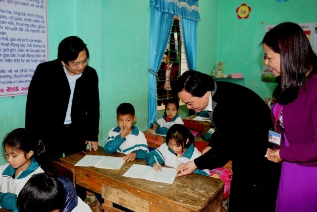Bộ trưởng Phùng Xuân Nhạ hỏi han một học sinh lớp 3 trường tiểu học Văn Hán 1 (tỉnh Thái Nguyên)