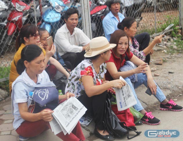 Tại điểm thi Đại học Công nghiệp Hà Nội, sau khi thi sinh vào phòng thi, nhiều phụ huynh vẫn đợi con ngoài cổng trường. Nhiều người cho biết họ không an tâm ra về. (Ảnh: Thùy Linh)