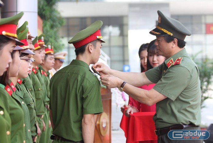 Thiếu tướng Bùi Minh Giám - Phó Tổng Cục trưởng Tổng cục Chính trị Công an nhân dân gắn quân hàm cho các học viên Học viện Cảnh sát nhân dân (Ảnh: Hà Linh)