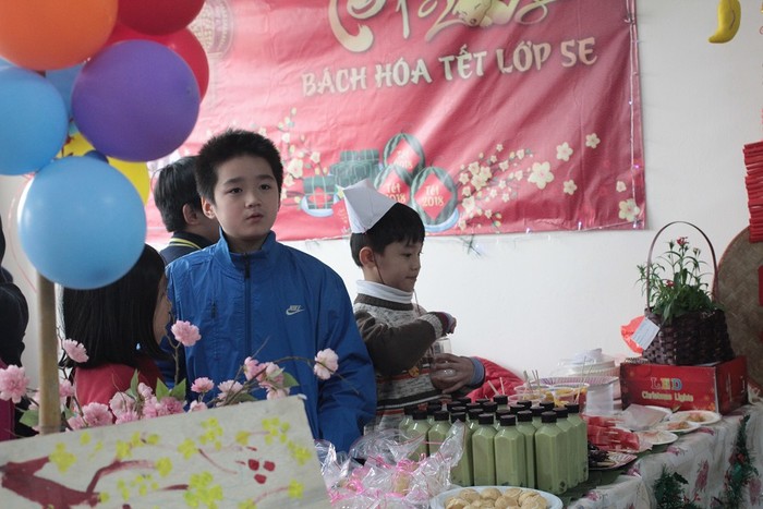 Các em học sinh tham gia bán hàng tại hội chợ.