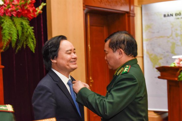 Bộ trưởng Phùng Xuân Nhạ nhận kỷ niệm chương “Vì chủ quyền an ninh biên giới Tổ quốc” (Ảnh: Bộ Giáo dục và Đào tạo)