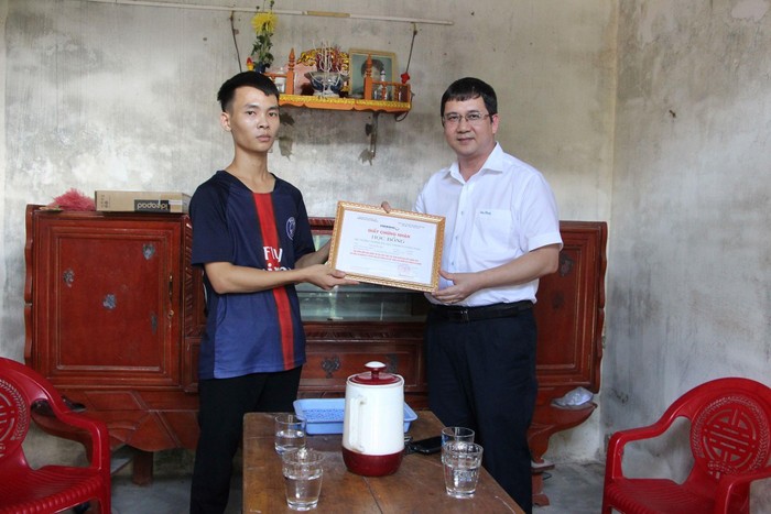 Phó giáo sư Phạm Thành Huy – Hiệu trưởng Trường Đại học Phenikaa trao giấy chứng nhận học bổng cho tân sinh viên Trần Quốc Huy. (Ảnh nhà trường cung cấp)