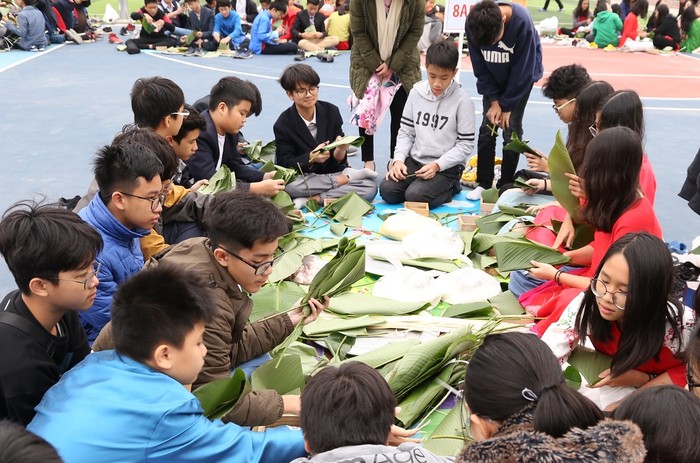 Trong lễ hội, các em học sinh được tham gia gói bánh chưng (Ảnh nhà trường cung cấp)