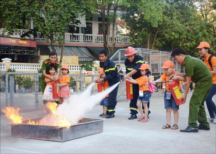 Hướng dẫn trẻ dùng bình bọt khi dập lửa (ảnh: nguồn Báo Thừa Thiên Huế)