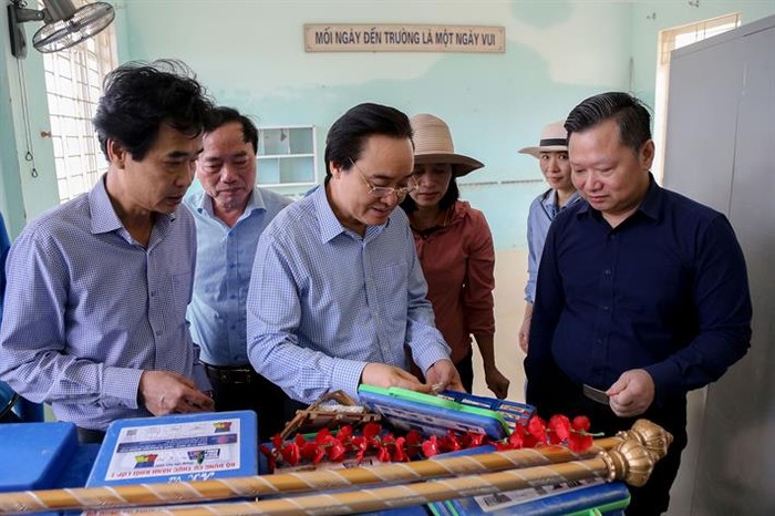 Bộ trưởng Phùng Xuân Nhạ kiểm tra những đồ dùng học tập còn sót lại tại Trường Tiểu học Hàm Ninh (ảnh: moet.gov.vn)