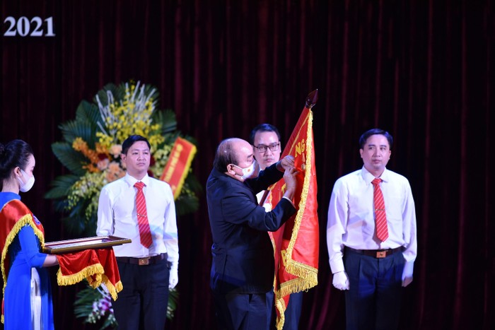 Chủ tịch nước Nguyễn Xuân Phúc gắn Huân chương Lao động hạng Nhất lên lá cờ truyền thống Trường Đại học Sư phạm Hà Nội