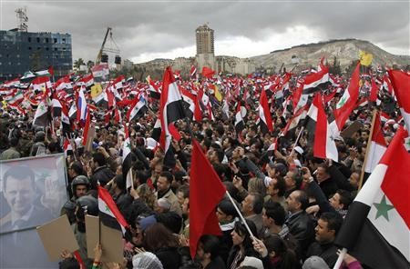 Đám đông người tuần hành vẫy cờ ủng hộ Tổng thống al-Assad
