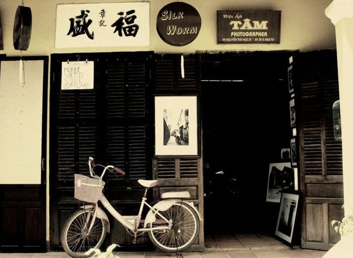 Hình ảnh một của hàng bán tranh và đồ cổ, chiếc xe đạp dựng trước cửa gợi một cảm giác bình yên lạ lùng.