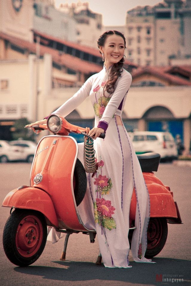 Trong tà áo dào truyền thống, Thu Thảo yêu kiều, duyên dáng bên chiếc xe Vespa màu cam ấn tượng và nổi bật