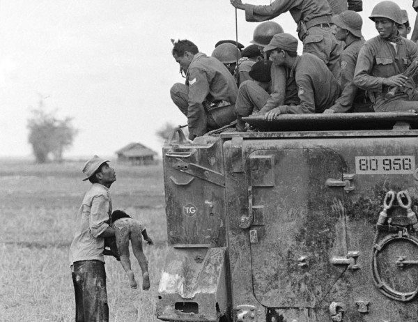 Bức ảnh được chụp vào tháng 3 năm 1964. Một người cha bế đứa con của mình đã thiệt mạng khi lực lượng chính phủ Việt Nam Cộng hòa truy đuổi du kích ở một ngôi làng gần biên giới Campuchia. Bức ảnh này đã giúp phóng viên Horst Faas giành được giải thưởng Pulitzer năm 1965.