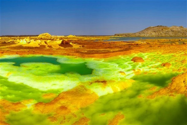 1. Dallol, Ethiopia – Nơi nóng nhất thế giới Dallol nằm ở đông bắc Ethiopia gần biên giới tranh chấp Eritrean. Nằm ở khu vực thấp hơn mực nước biển khoảng 116m, Dallol còn được mệnh danh là núi lửa trên cạn thấp nhất thế giới và là vùng đất có nhiệt độ trung bình năm 34,4 độ C, cao nhất thế giới. Cả vùng đất lạ kỳ này phủ một màu đỏ xẫm, pha lẫn màu xanh lá, vàng và trắng của muối, các ao nước và dòng suối khoáng nóng.