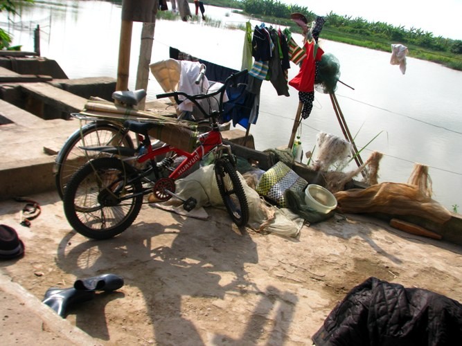 Trên sân nhà, 2 chiếc xe đạp của những đứa con nhà ông Vươn, ông Quý được che nắng rất đơn giản. Vì ngôi nhà quá nhỏ cho 2 gia đình, nên đa số những vật dụng đều phải để ngoài sân.
