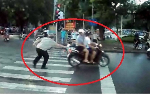 Một người nước ngoài đang cố kéo một chiếc xe đi ngược làn đường ở Hà Nội.