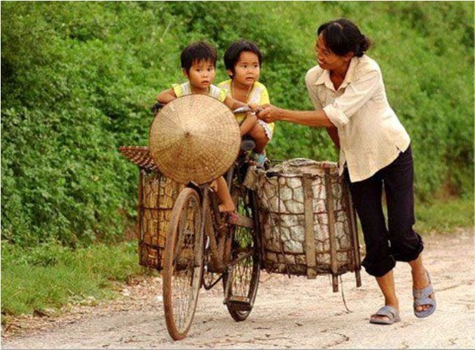 Ngày hôm nay, bức ảnh người phụ nữ nghèo ở một vùng quê chở 2 con trên chiếc xe đạp xuất hiện trên mạng xã hội facebook như một bức tranh bình dị, mà xúc động về tình cảm gia đình.
