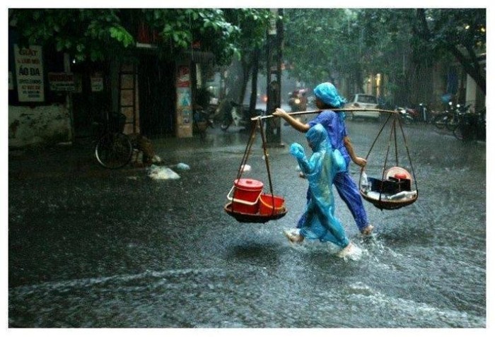 Thêm một bức ảnh về hai mẹ con bán hàng rong dưới mưa rào, trên mặt đường ngập nước cũng khiến nhiều độc giả xúc động.
