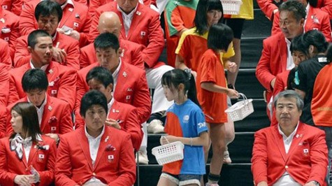 Các em bé đi trao “huy chương sóng thần” cho các thành viên đoàn Nhật dự Olympic 2012 - Ảnh: AP