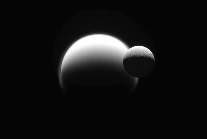 Mặt trăng Rhea bay phía trước Titan, cả 2 đều là các mặt trăng bay quanh quỹ đạo của Sao Thổ.