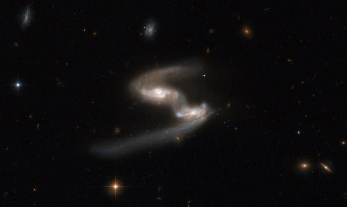 17. Bức ảnh tuyệt đẹp về ESO 77-14 giống như một vũ điệu không gian được thể hiện bởi một cặp thiên hà có kích thước tương đương nhau. Hai dấu hiệu rõ ràng về cuộc chiến lực hút giữa hai dải thiên hà là cây cầu vật chất kết nối chúng với nhau và sự tách rời hai cơ thể chính.Thiên hà bên phải có cánh tay dài hơn, màu xanh nhạt trong khi thiên hà kia có cánh tay ngắn hơn và màu đỏ hơn.Cặp tương tác này nằm trong chòm sao Indus,Ấn Độ.