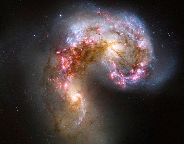 21. Các thiên hà Antennea và một cặp hợp nhất hai thiên hà xoắn ốc Antennae: Hai thiên hà này bắt đầu tương tác với nhau cách đây vài triệu năm và tạo ra các thiên hà Antennae, là thế hệ thiên hà trẻ nhất có chứa hàng chục ngàn ngôi sao. Những đốm màu cam phía bên trái và phải là lõi của hai thiên hà ban đầu,vùng màu nâu là các ngôi sao già. Hai thiên hà được tô điểm bằng các vùng sao xanh lấp lánh bao quanh do khí hydro phát sáng. Những thiên hà Antennea giống như những cánh tay xòe ra xung quanh lõi của hai thiên hà gốc.