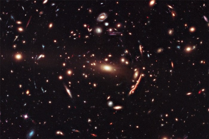 22. Nằm trong chòm sao Virgo, Macs 1206 gồm nhiều dải thiên hà bị hút vào với nhau bởi lực hấp dẫn. Lực hấp dẫn uốn cong khoảng không xung quanh tạo ra hình ảnh những dải ngân hà xa xôi bị biến dạng . Vệt màu cam phía bên phải là hình ảnh một thiên hà bị bóp méo.