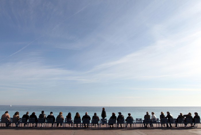 Rất nhiều người ngồi tận hưởng cái nắng ấm áp của mùa Xuân trên bãi biển Promenade des Anglais, phía Đông Nam thành phố Nice, nước Pháp, 11/03/2012.
